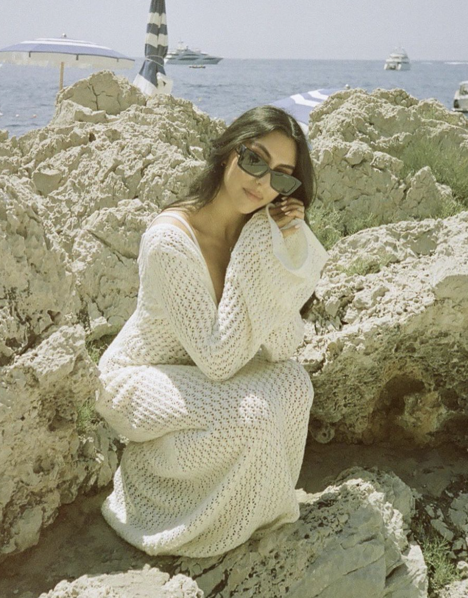 A snug, crochet dress perfect for both beach lounging, blending comfort with seaside elegance.